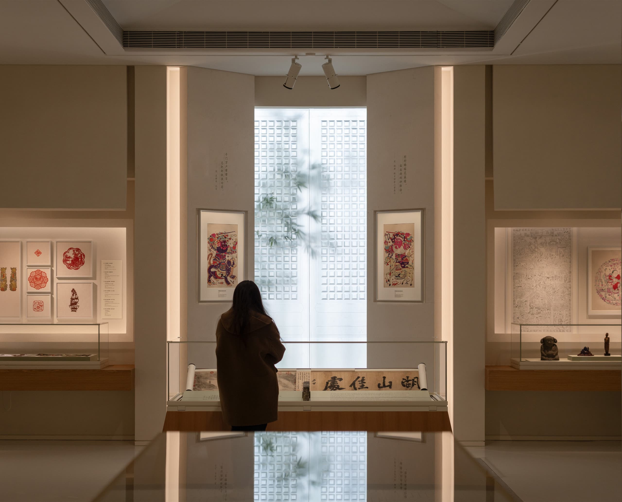 Besucher im Shanghai Museum East betrachtet Kalligrafie, beleuchtet mit ERCO Strahlern für optimale Konservierung.