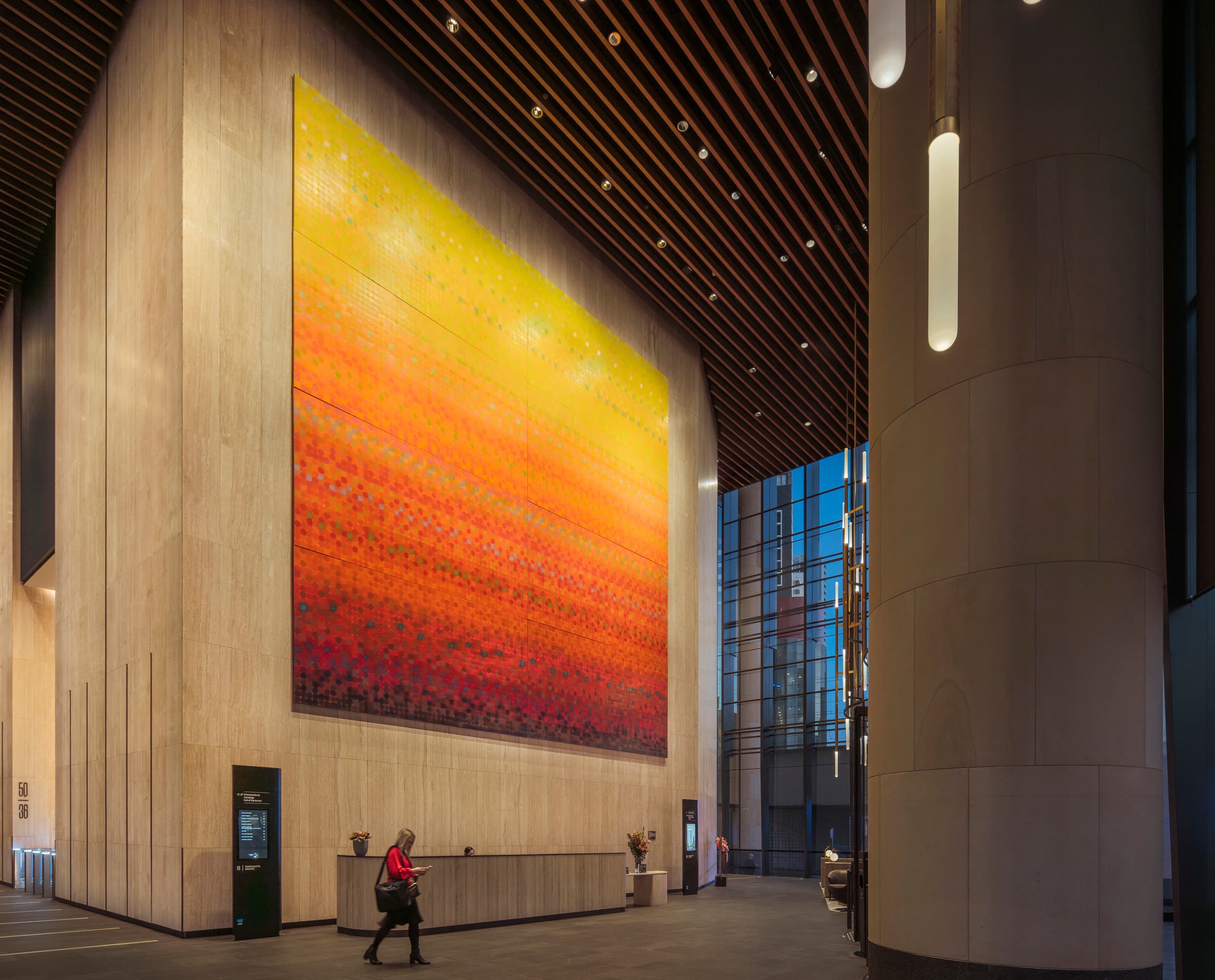 Parramatta Square Lobby mit Kunstwerk und ERCO Beleuchtung, die eine einladende Atmosphäre schafft.