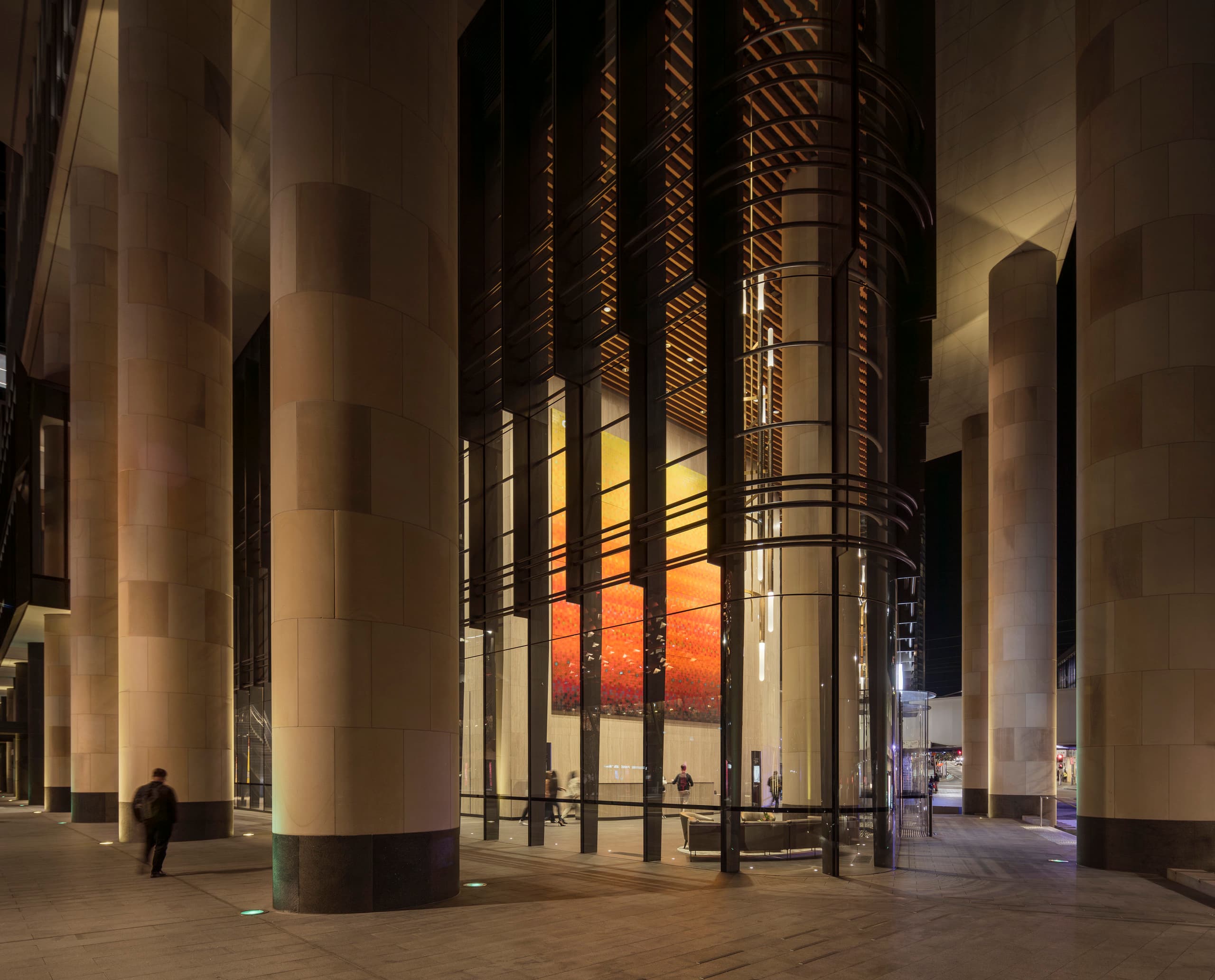 Parramatta Square bei Nacht: Beleuchtete Säulen und Fassade schaffen einladende Atmosphäre.