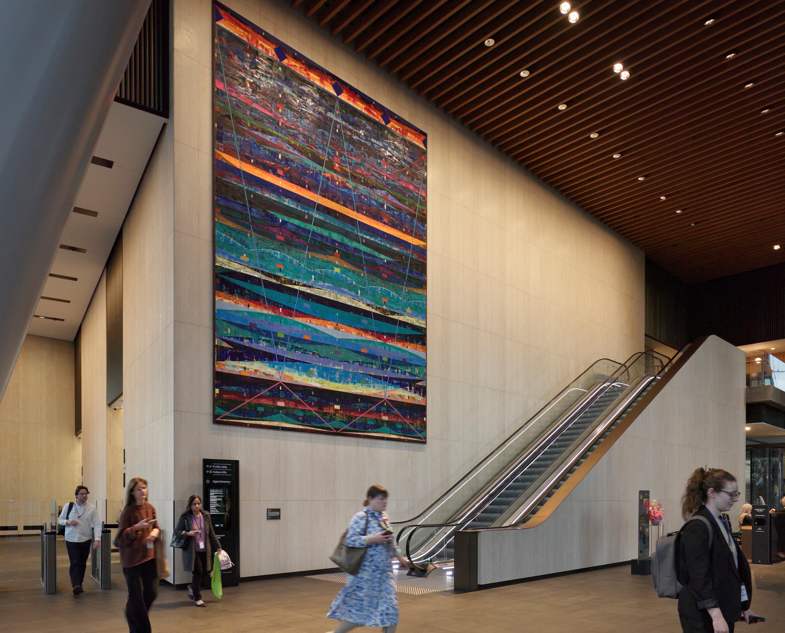 Parramatta Square Lobby mit Kunstwerk und Rolltreppe, beleuchtet mit ERCO Licht.