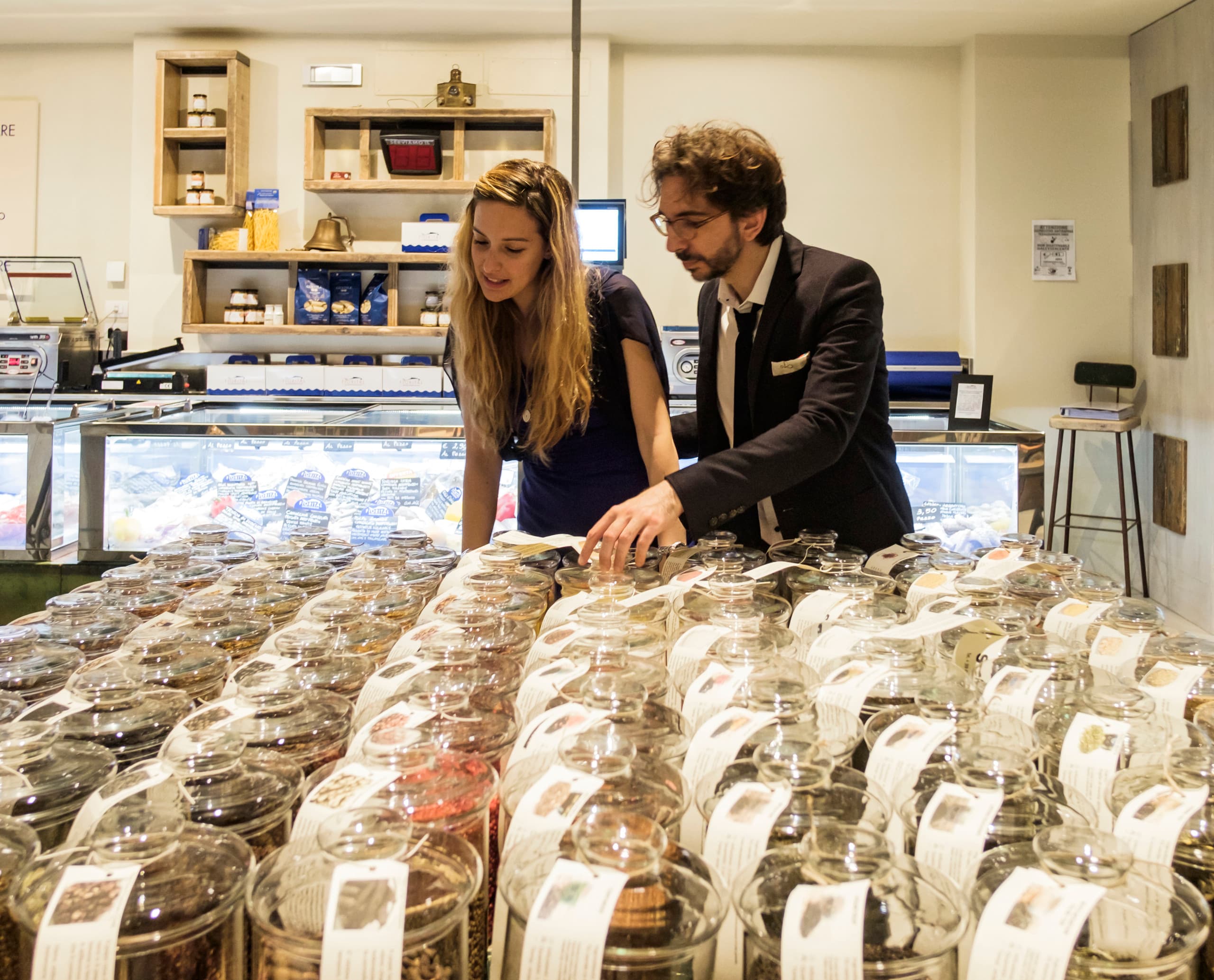 Kunden wählen Feinkost in Fiorital Delikatessen, Padua, beleuchtet mit ERCO LED-Lichtern.