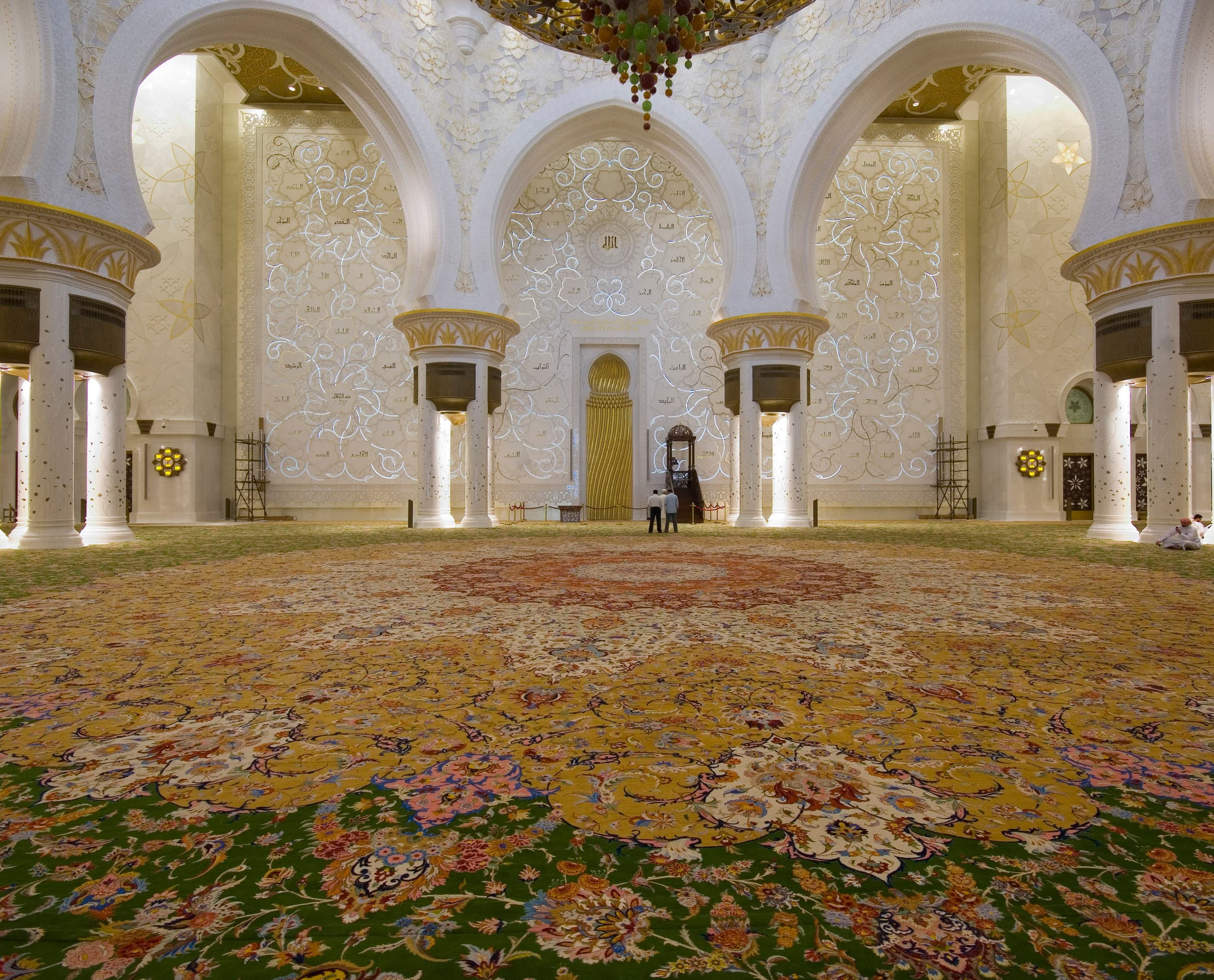 Innenansicht der Sheikh Zayed Moschee in Abu Dhabi mit Beleuchtung und Teppich.