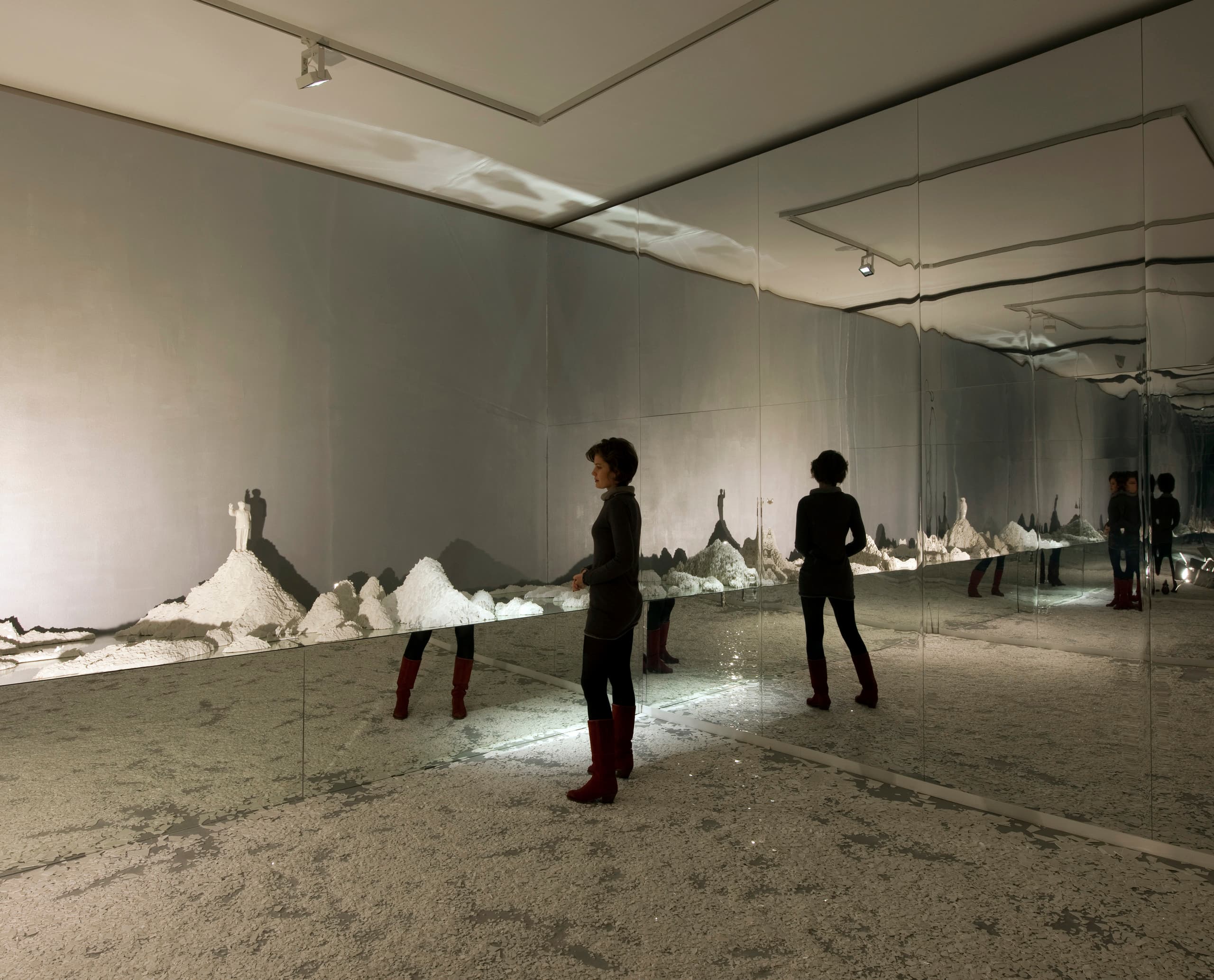 ERCO LED-Beleuchtung im Palazzo Bembo: Besucher betrachtet Kunstinstallation mit Spiegeln und Licht.