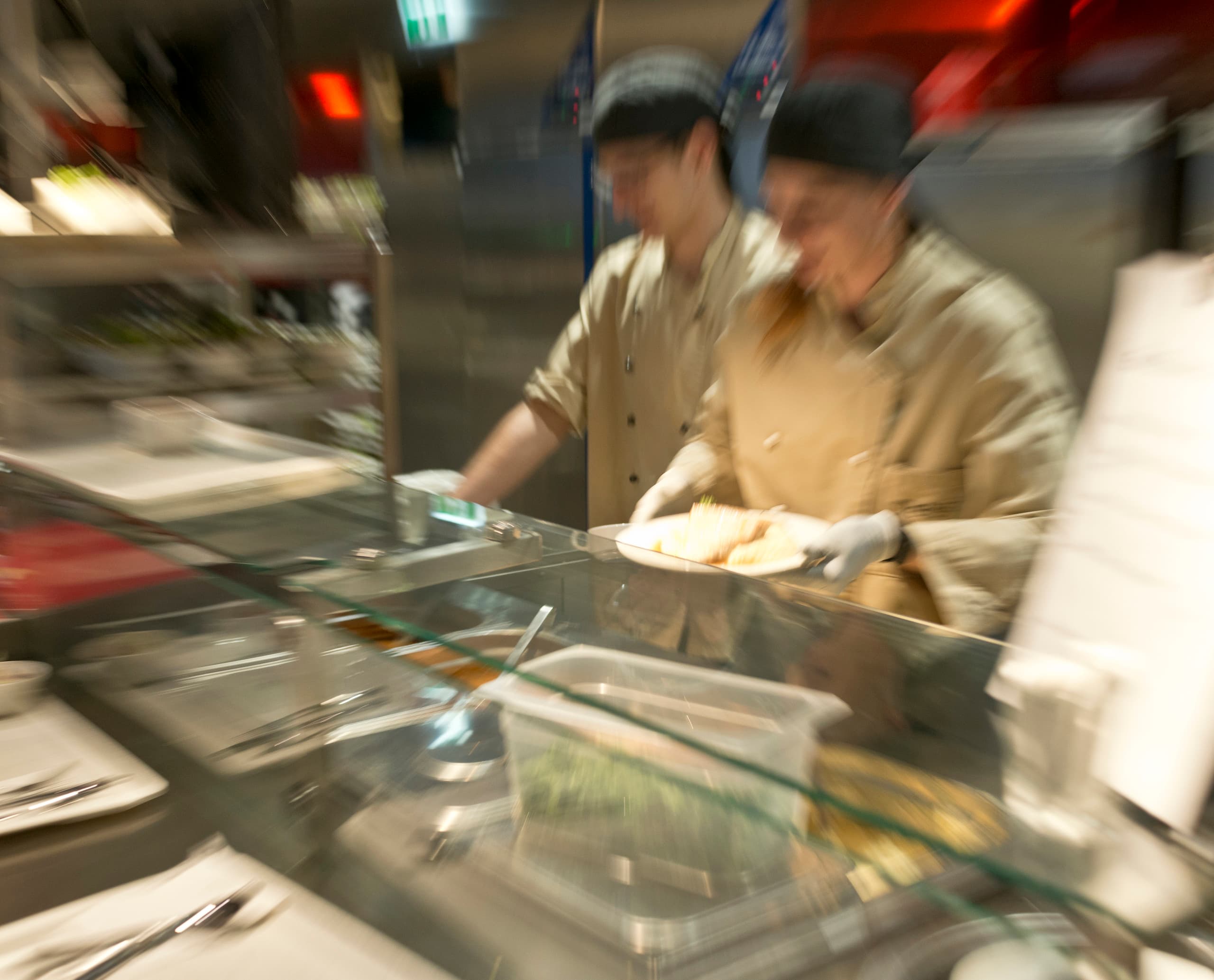 Essensausgabe in der Cafeteria der Wirtschaftsuniversität Wien mit warmweißer Beleuchtung.