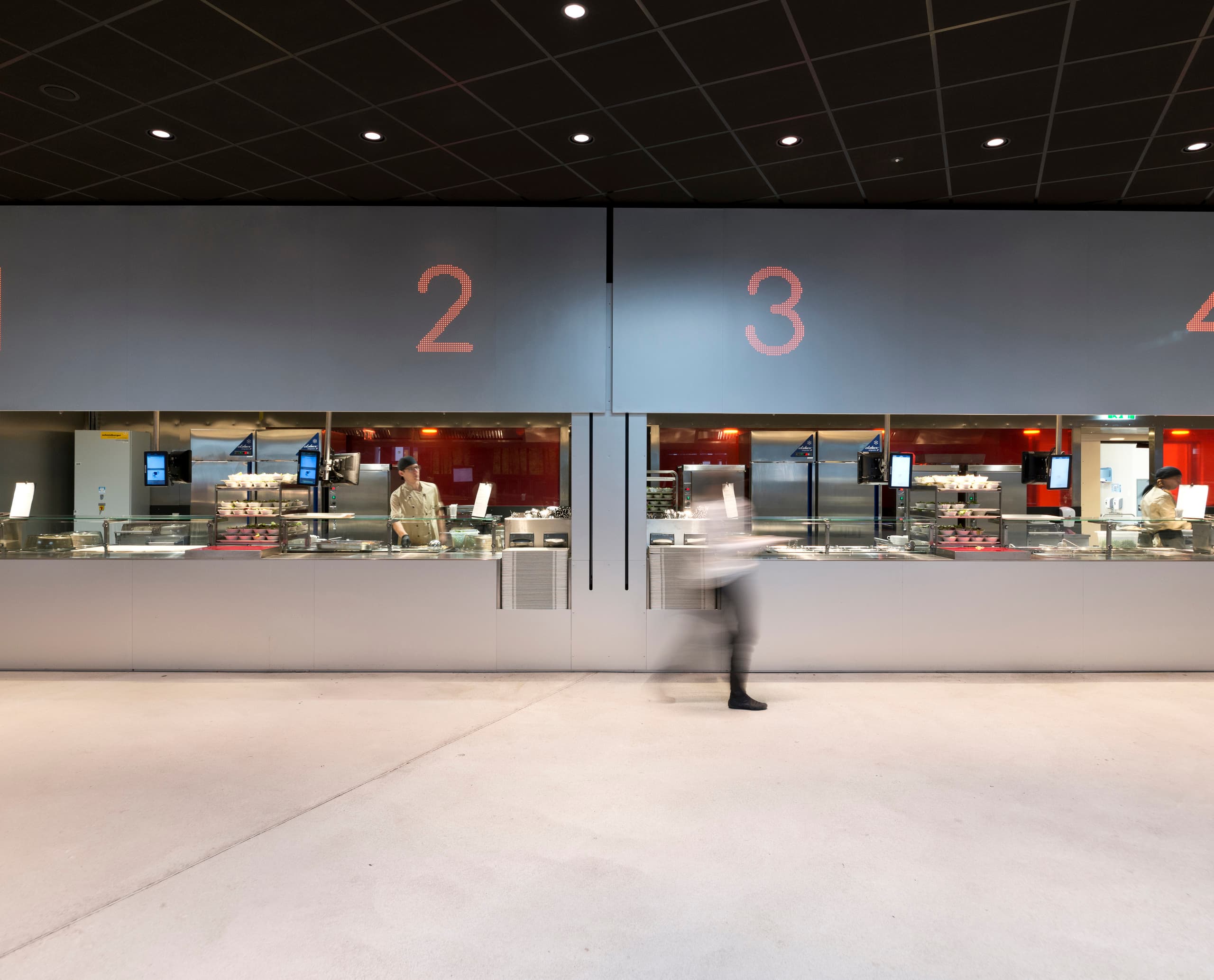 Cafeteria der Wirtschaftsuniversität Wien mit LED-Beleuchtung und Essensausgabe.