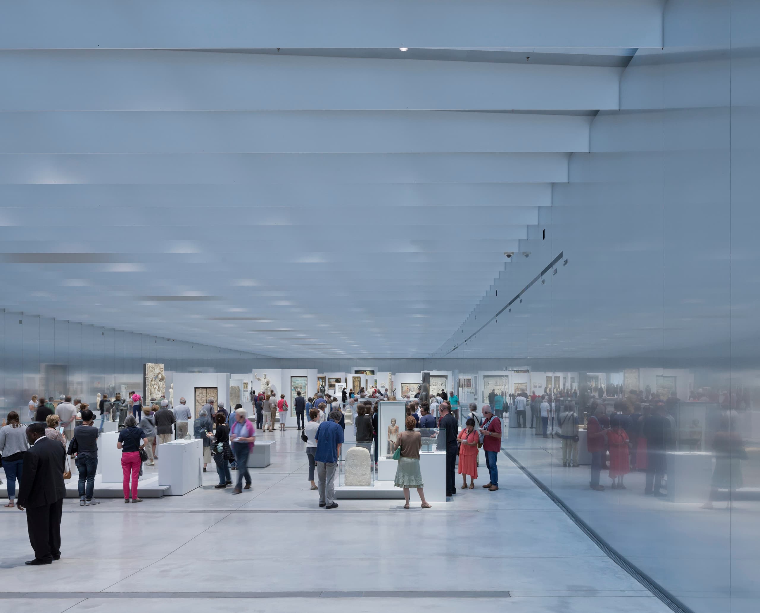 Innenansicht des Louvre Lens Museums mit Besuchern und ERCO LED-Beleuchtung.