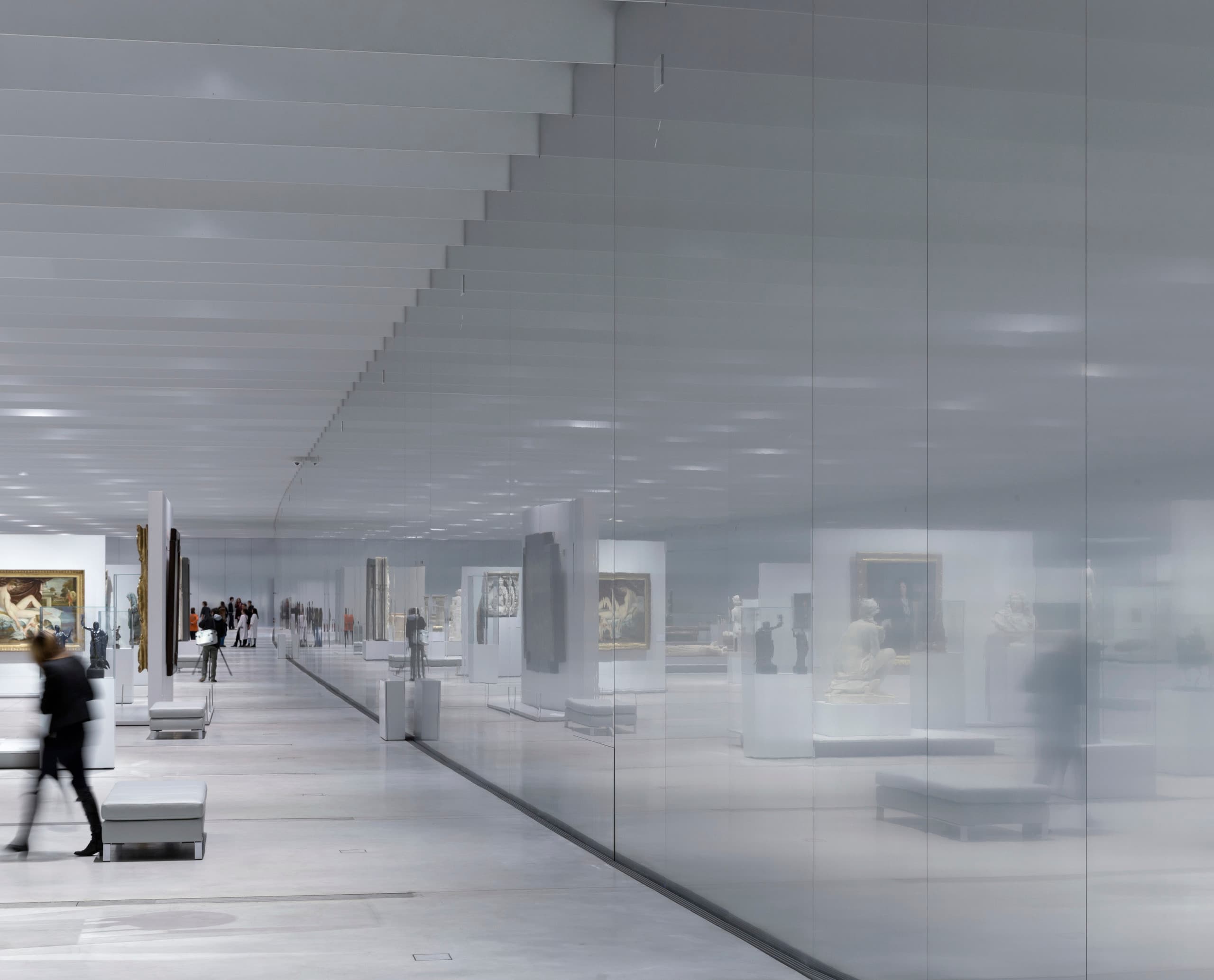 Innenansicht des Louvre Lens Museums mit ERCO LED-Beleuchtung und Besuchern.