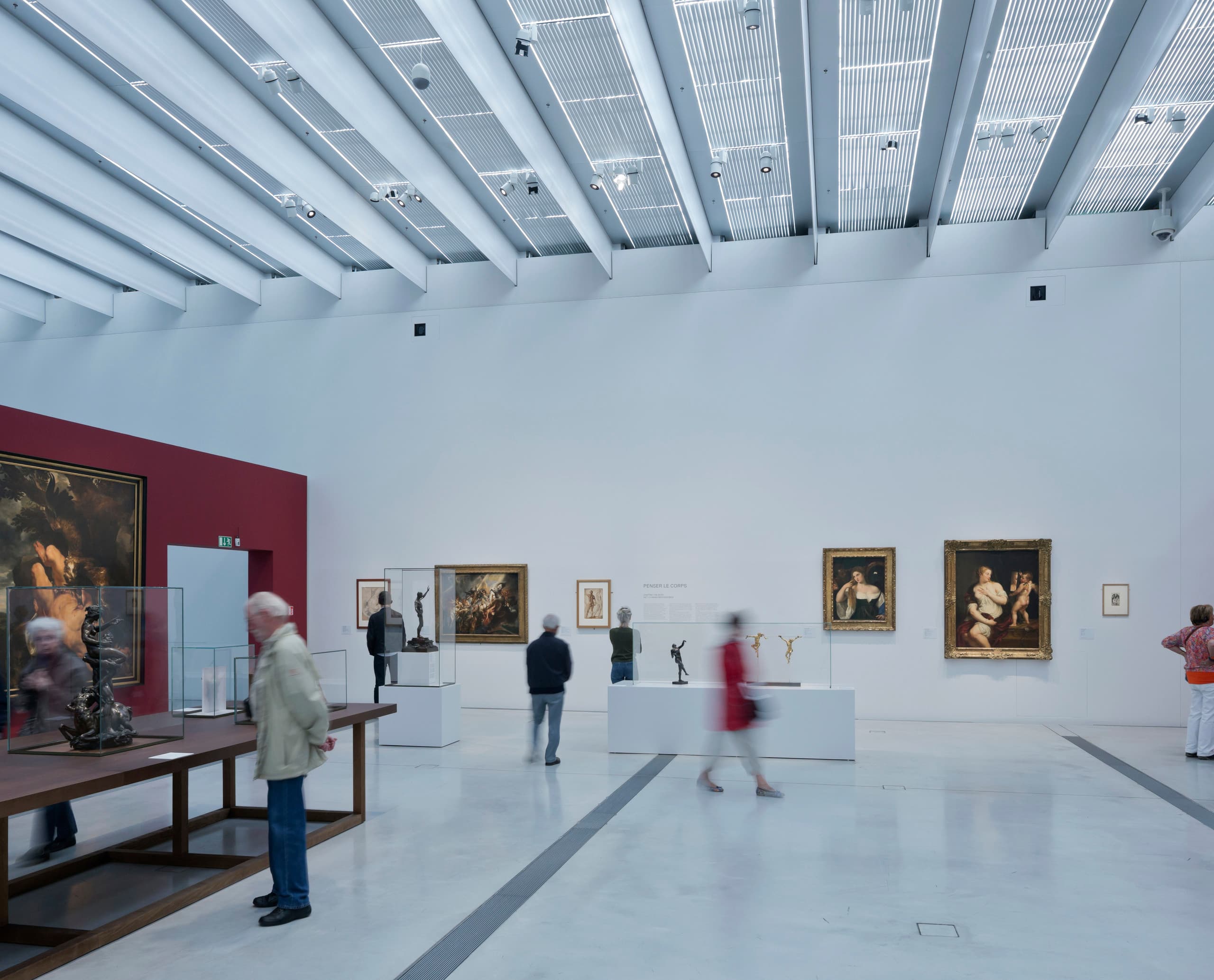 Innenansicht des Louvre-Lens Museums mit Kunstwerken und Besuchern, beleuchtet mit ERCO LED-Leuchten.