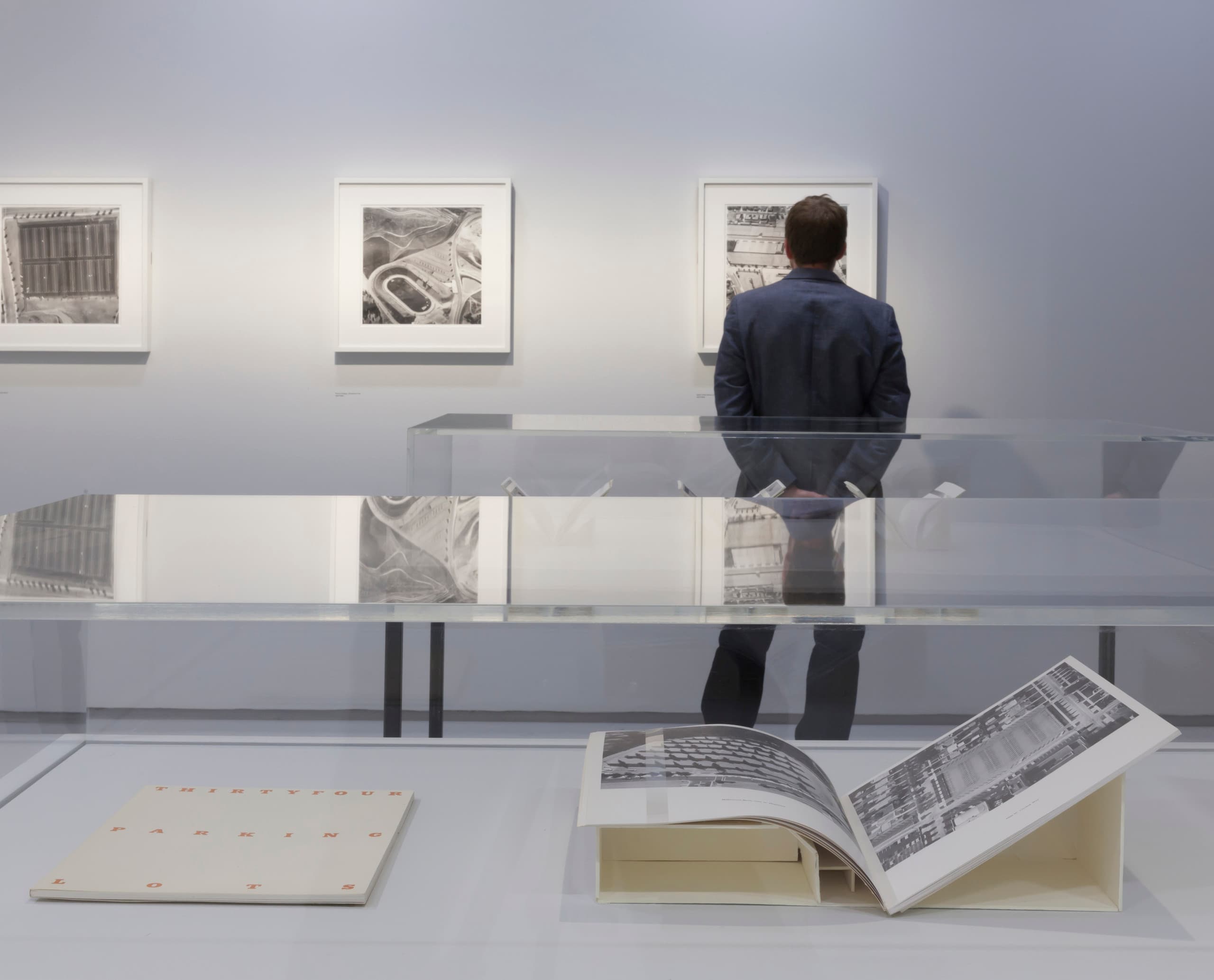 Besucher betrachtet Kunstwerke in der Barbican Art Gallery, beleuchtet mit ERCO LED-Leuchten.