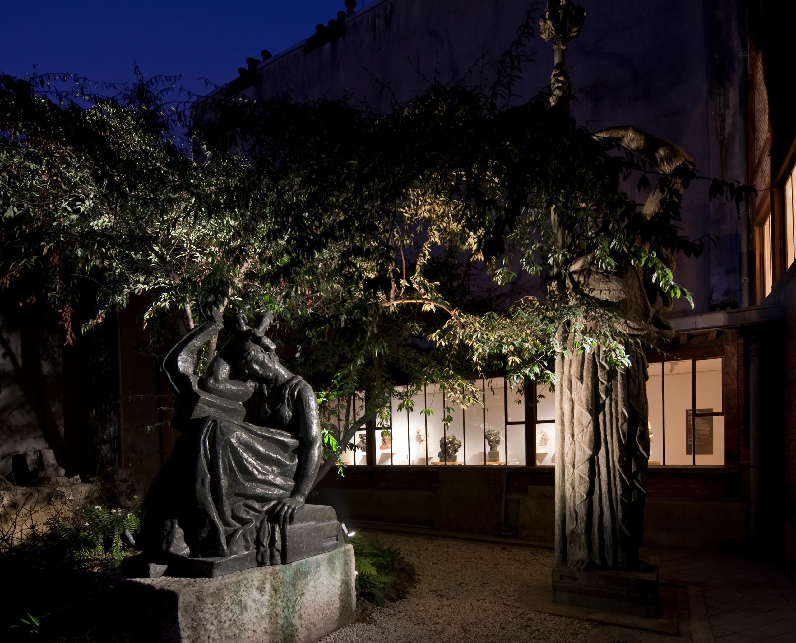 Beleuchtete Skulptur im Musée Bourdelle Garten, Paris. ERCO LED-Außenleuchten akzentuieren Kunst und Gartenarchitektur.