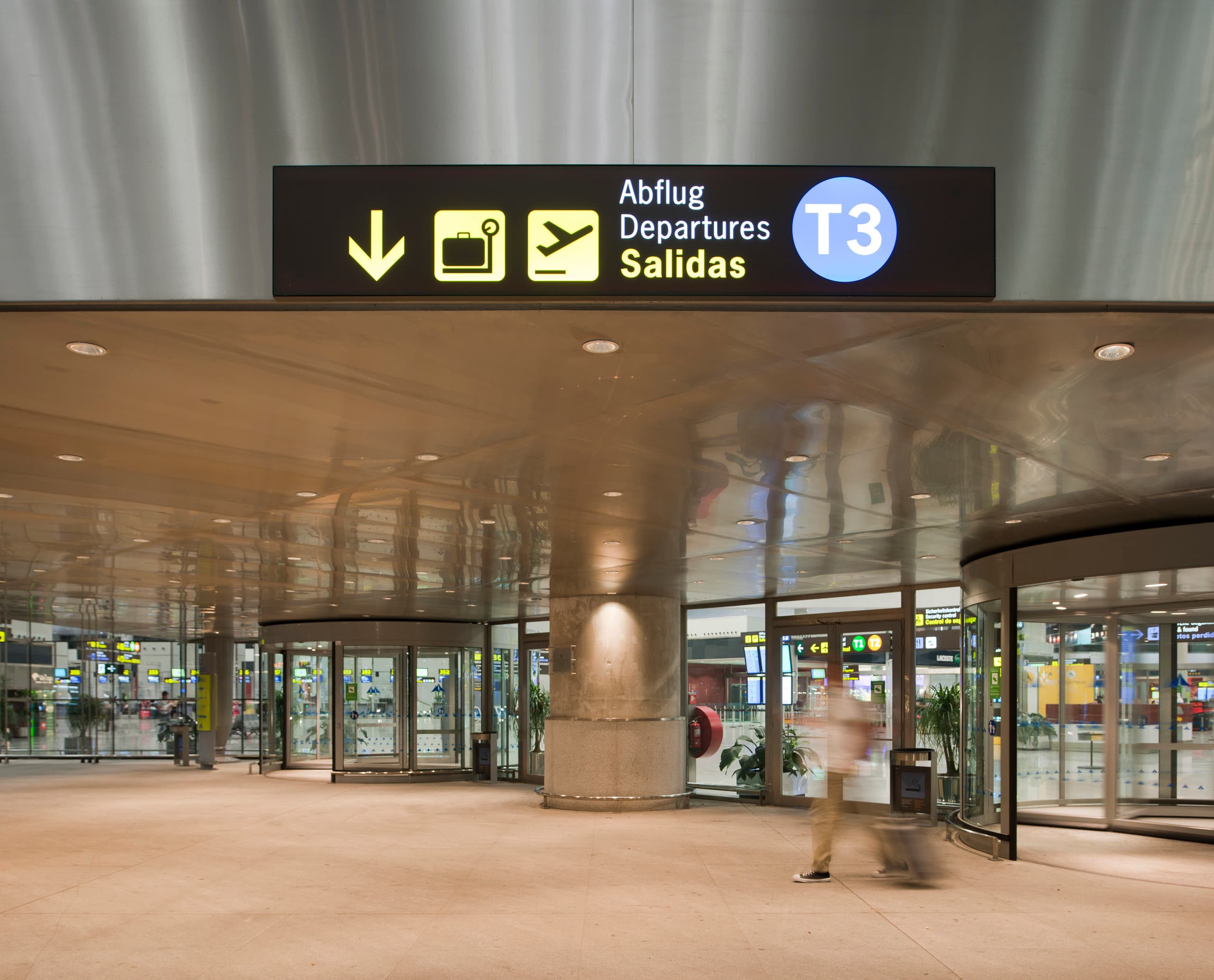 Flughafen Málaga Terminal 3: Beschilderung zu Abflug und Gepäckausgabe mit ERCO Downlights.
