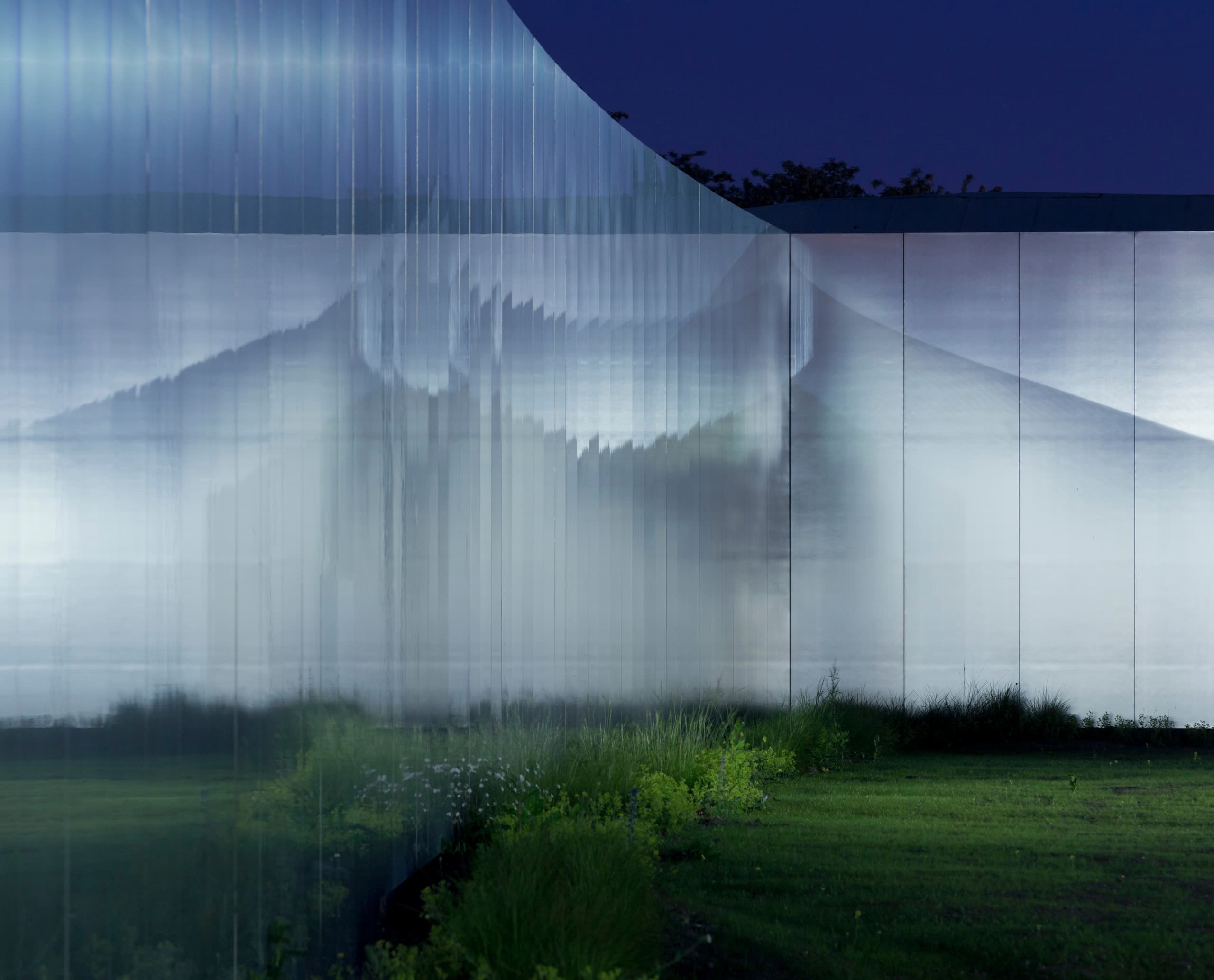 Louvre-Lens Museumsfassade bei Nacht, die moderne Architektur und Beleuchtung zeigt.