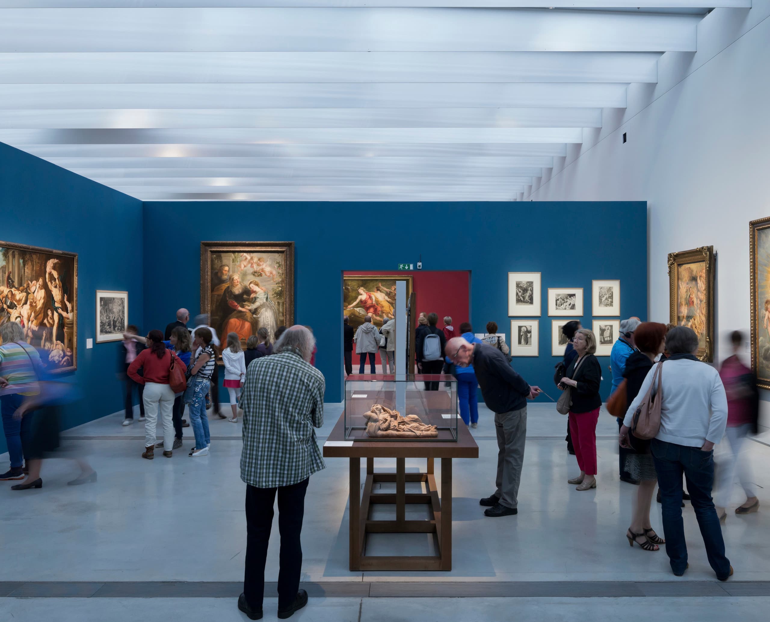 Besucher betrachten Kunstwerke im Louvre-Lens Museum, beleuchtet mit ERCO LED-Leuchten.