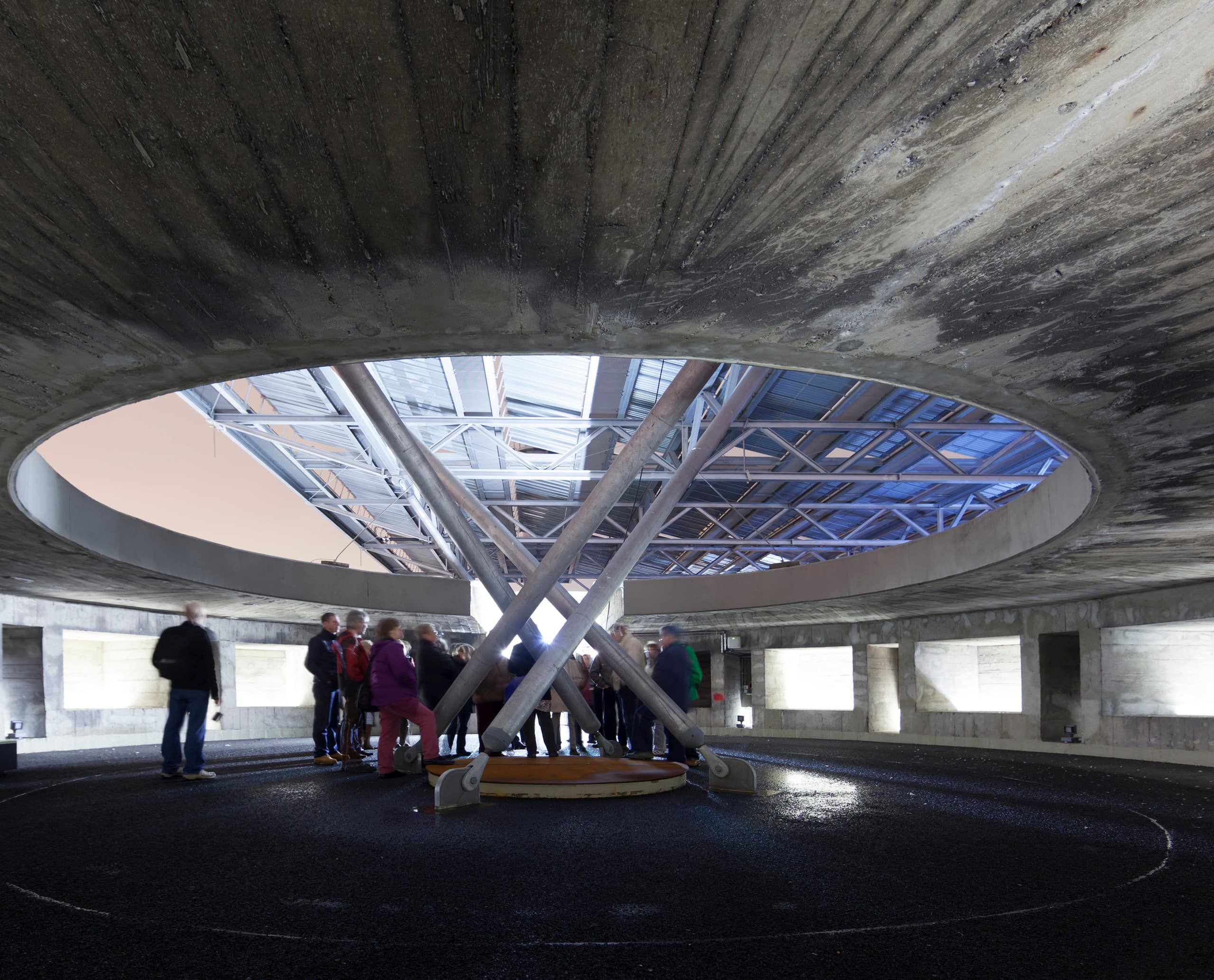 Innenansicht des Energiebunkers Hamburg mit Besuchern und Oberlicht, das Tageslicht hereinlässt.