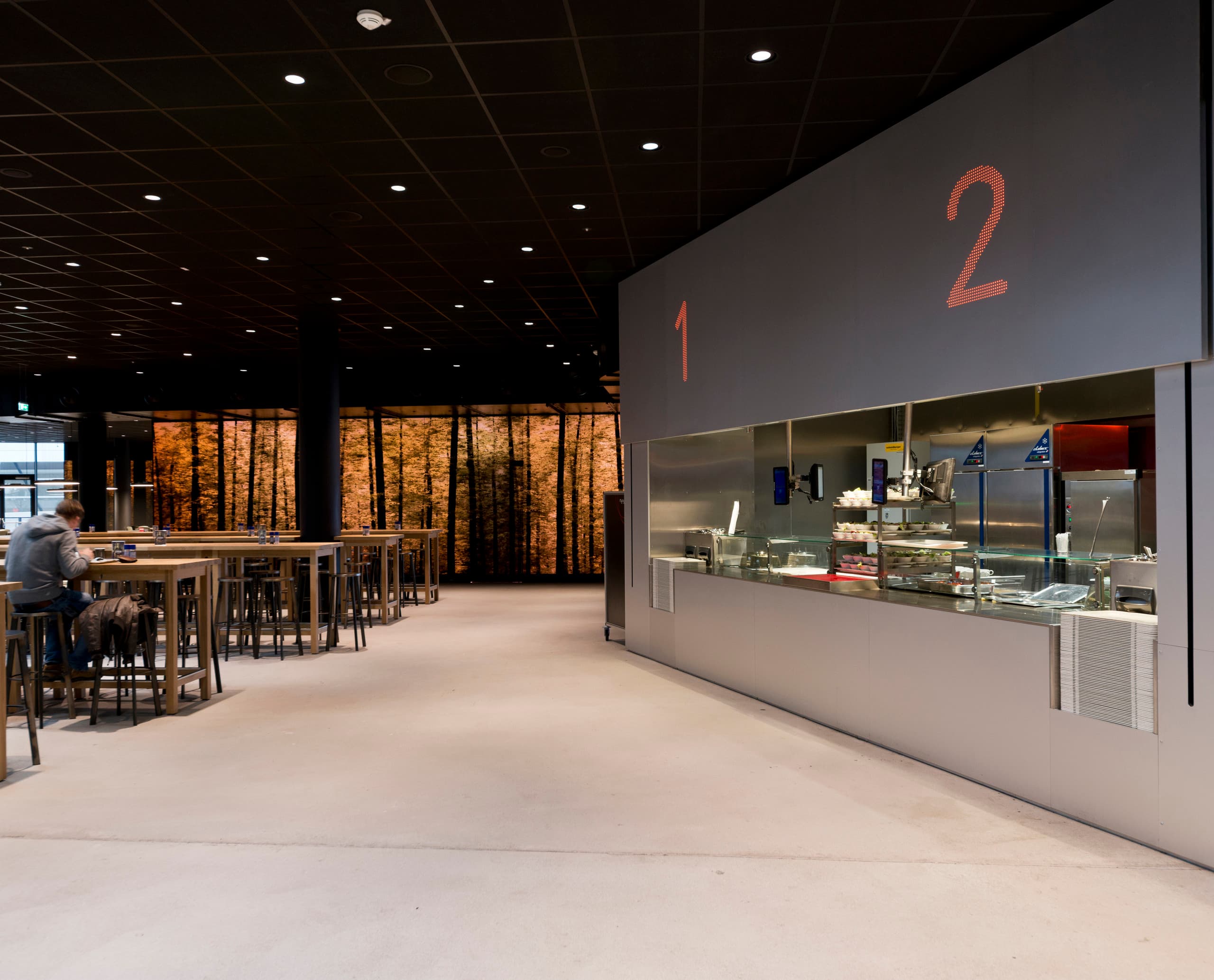 Cafeteria der Wirtschaftsuniversität Wien mit ERCO LED-Beleuchtung für soziale Interaktion.