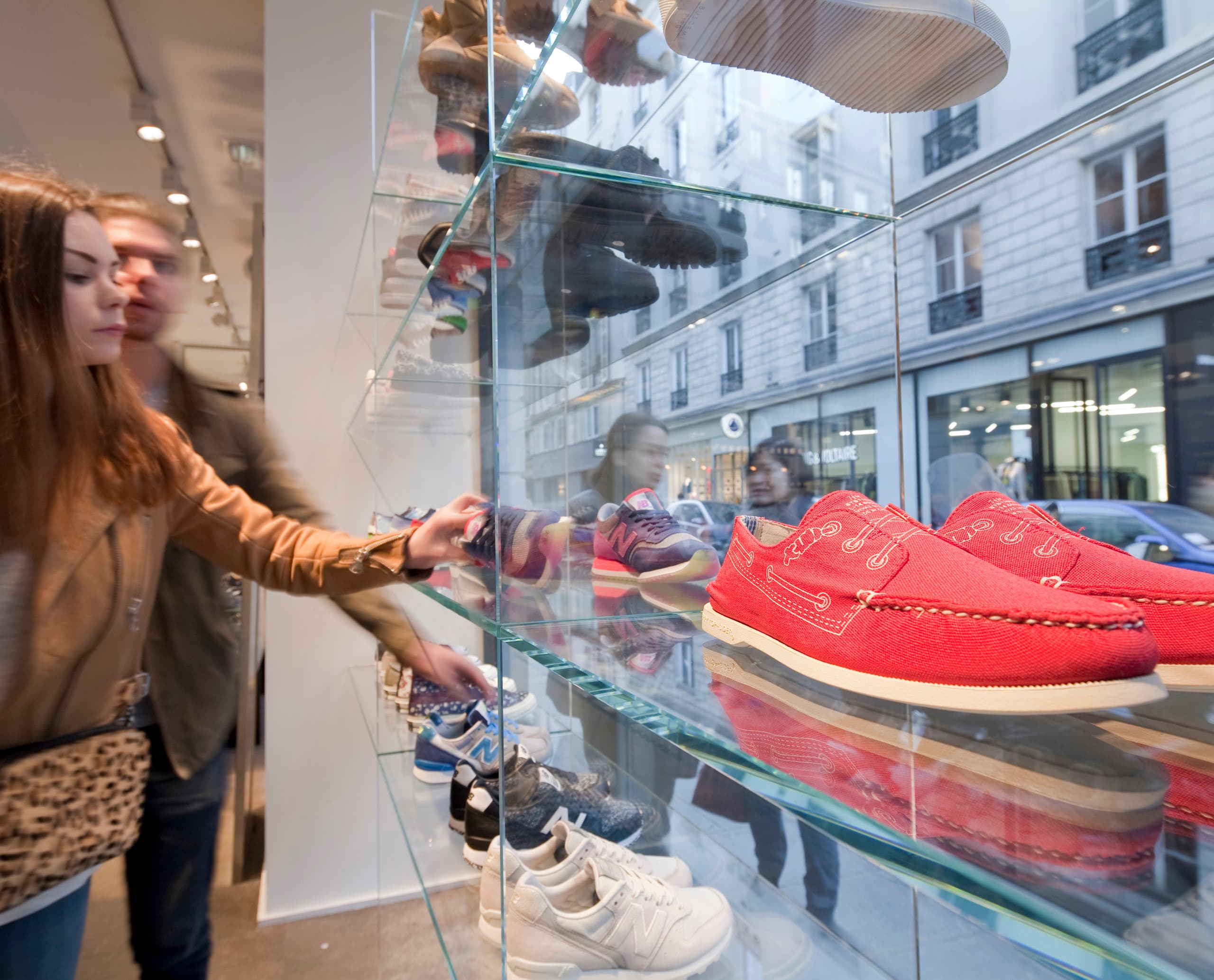 Kunden betrachten Schuhe im Colette Store, Paris, beleuchtet mit ERCO LED-Technologie.
