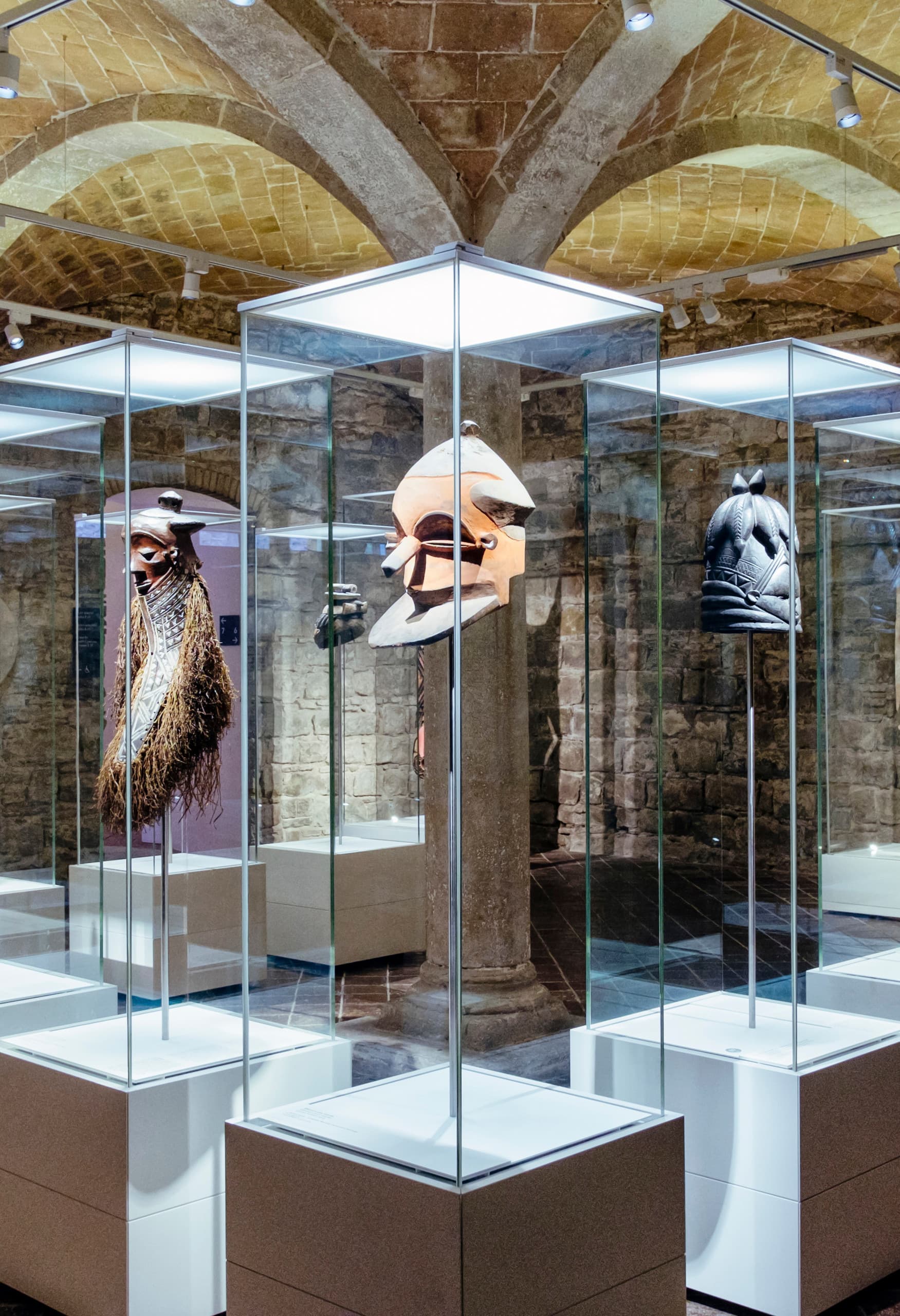 Afrikanische Masken in Vitrinen, beleuchtet mit ERCO Optec Strahlern im Museu de Cultures del Món, Barcelona.