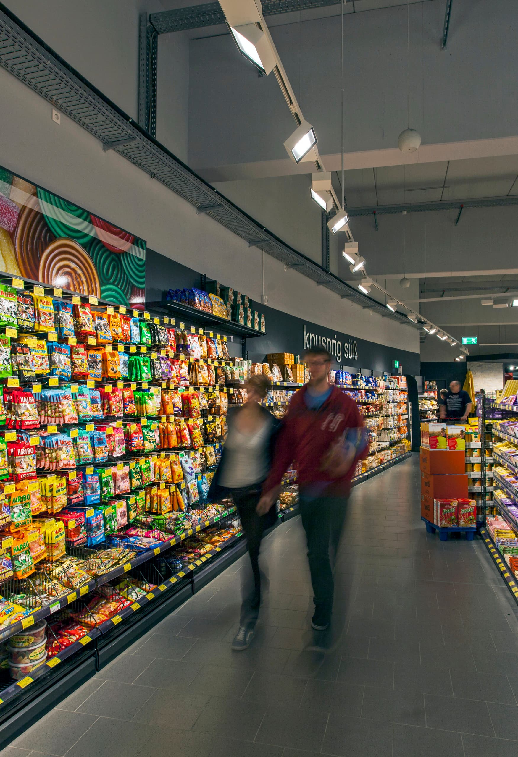 REWE Supermarkt in Hagen-Hohenlimburg mit Opton LED Akzentbeleuchtung für Süßwarenregale.