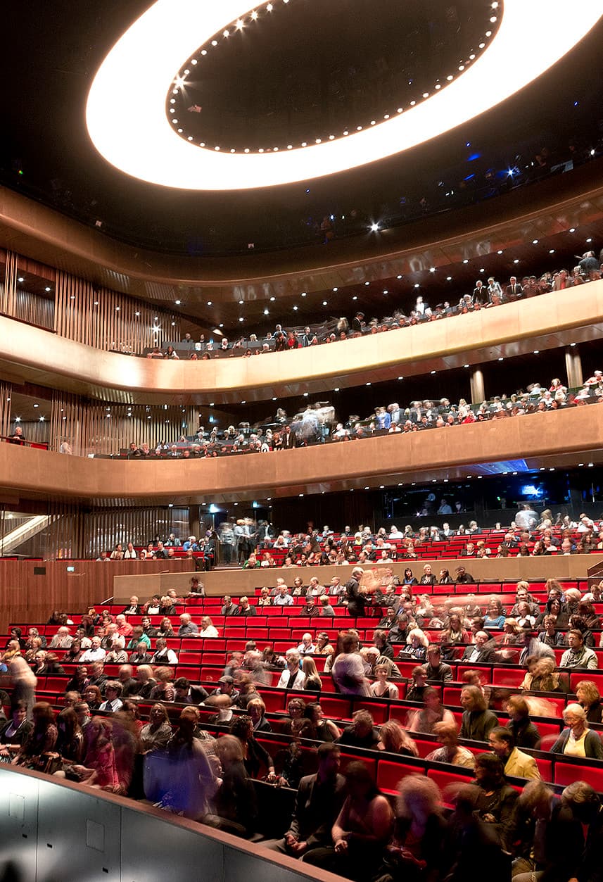 Innenansicht des Linzer Musiktheaters mit ERCO Beleuchtung und Publikum.
