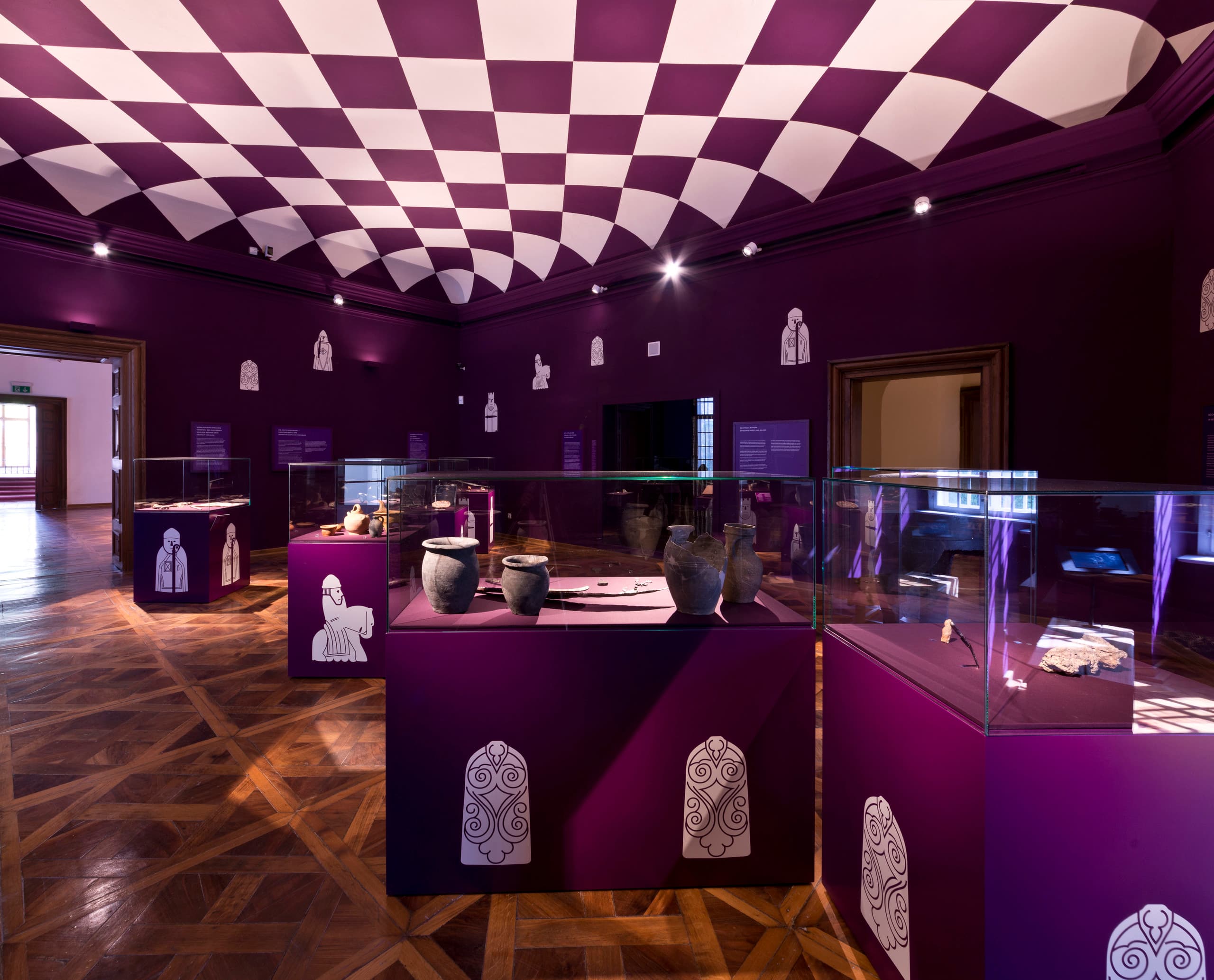 Innenansicht des MAMUZ Museums Mistelbach mit archäologischen Fundstücken in Vitrinen und besonderer Beleuchtung.