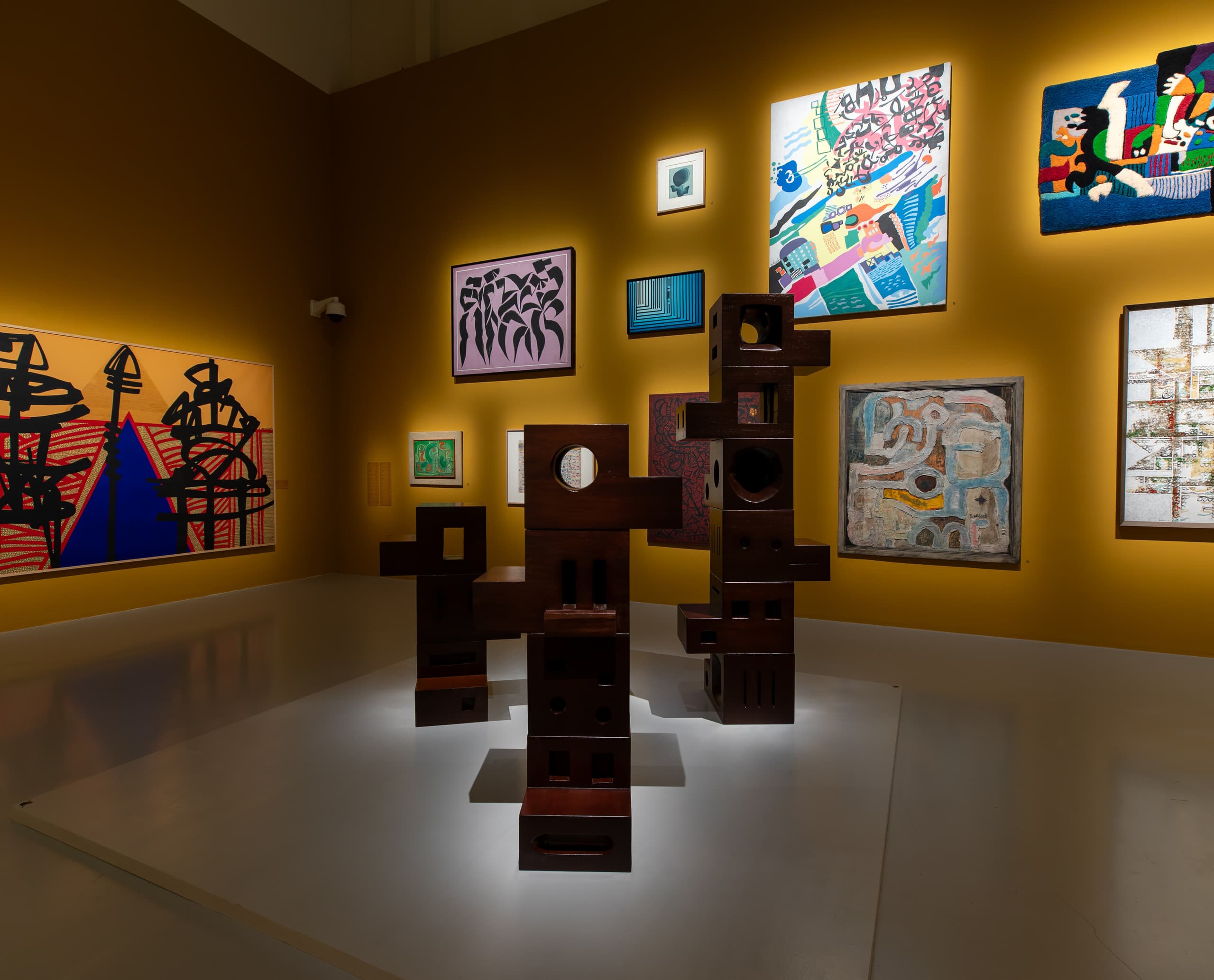 Akzentuierte Skulpturen und Gemälde in Ausstellungsraum.