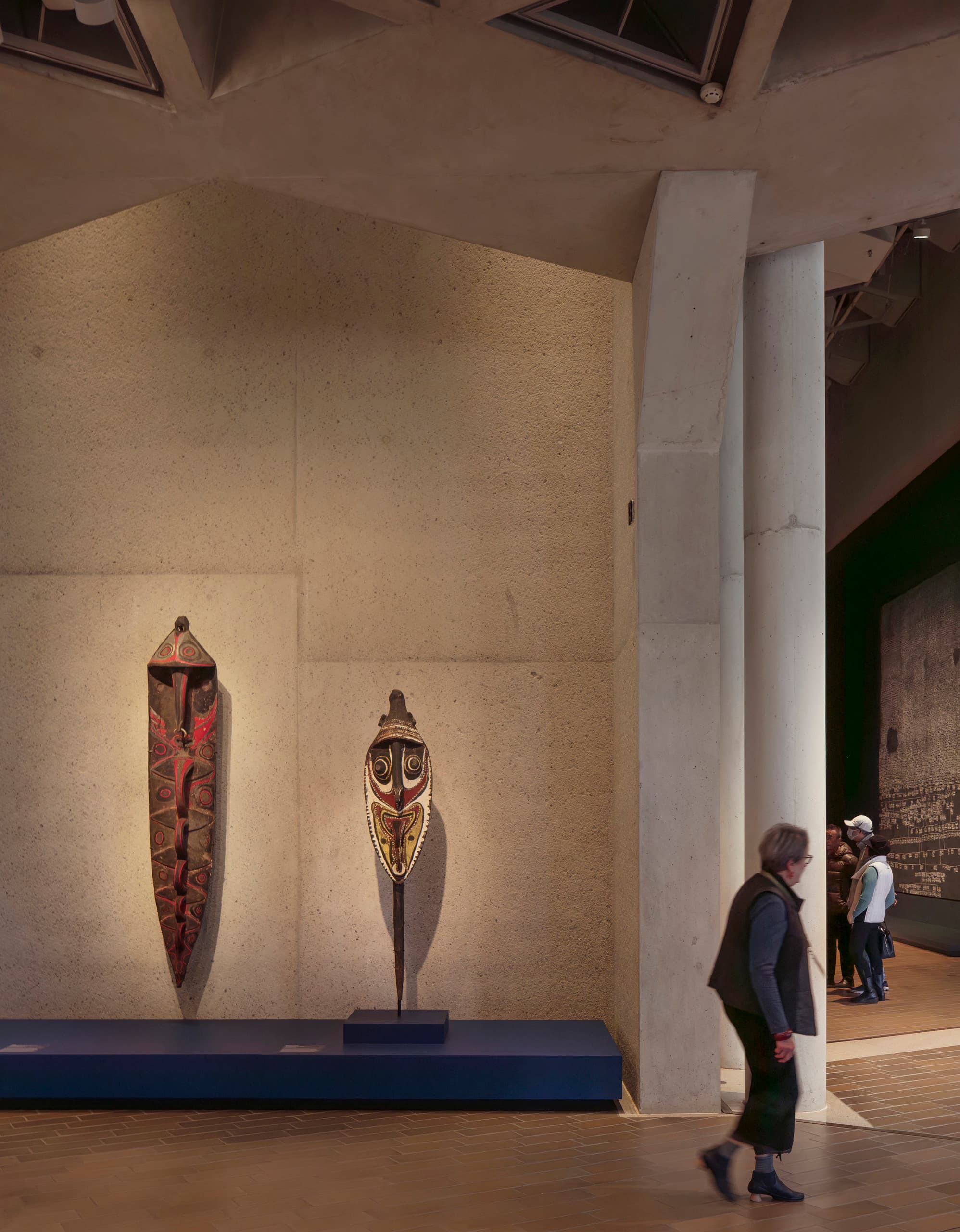 Zwei Skulpturen vor einer Wand im Museum.
