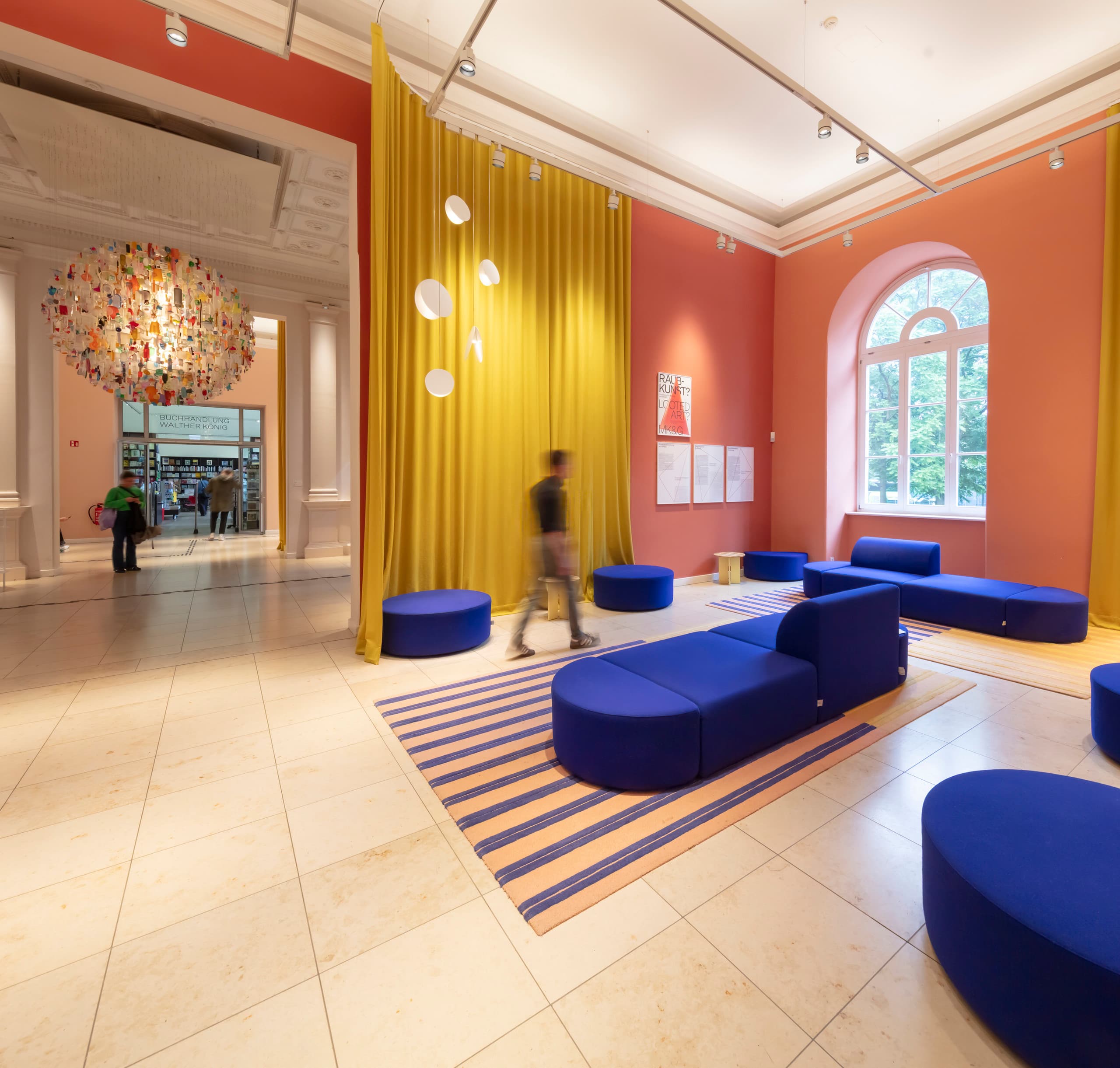 Foyer mit blauen Sofas und orangefarbenen Wänden.