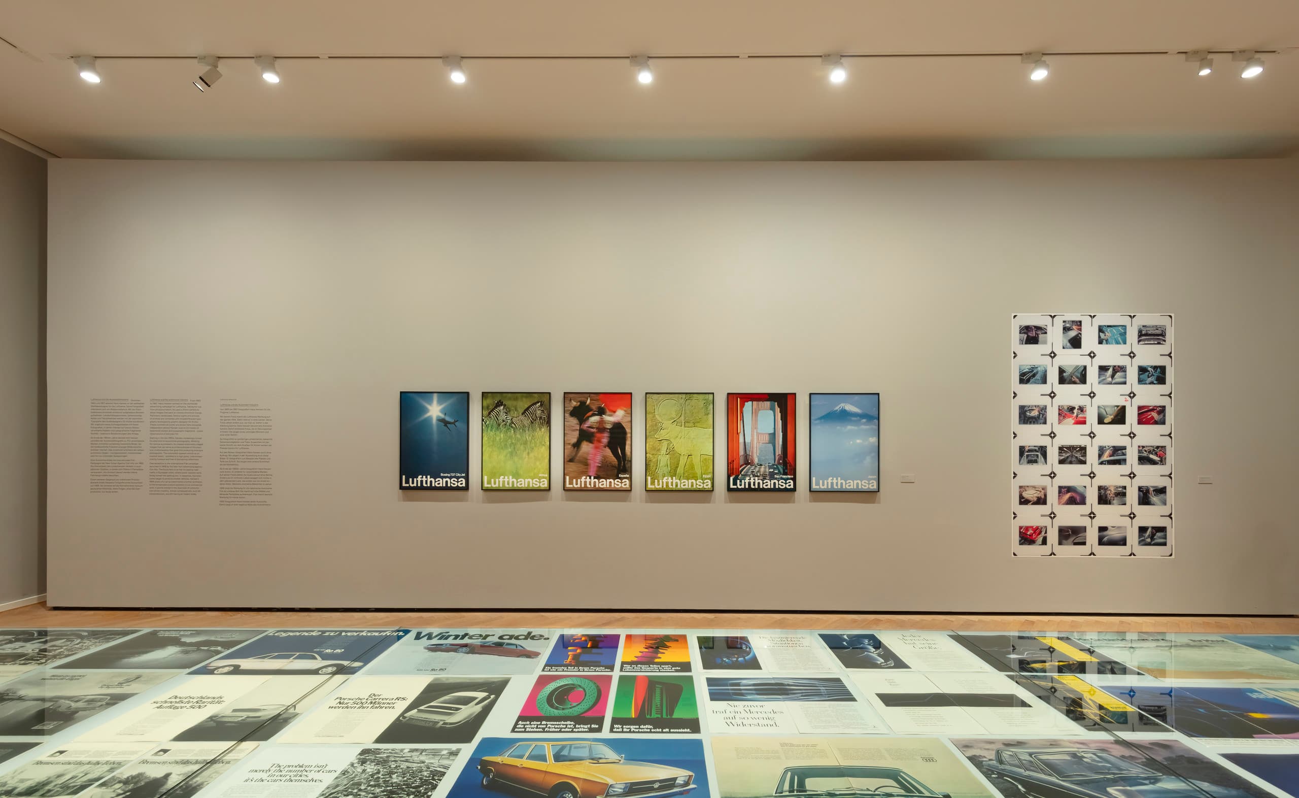 Ausgestellte Werbefotos an Wand und auf Präsentationstisch.