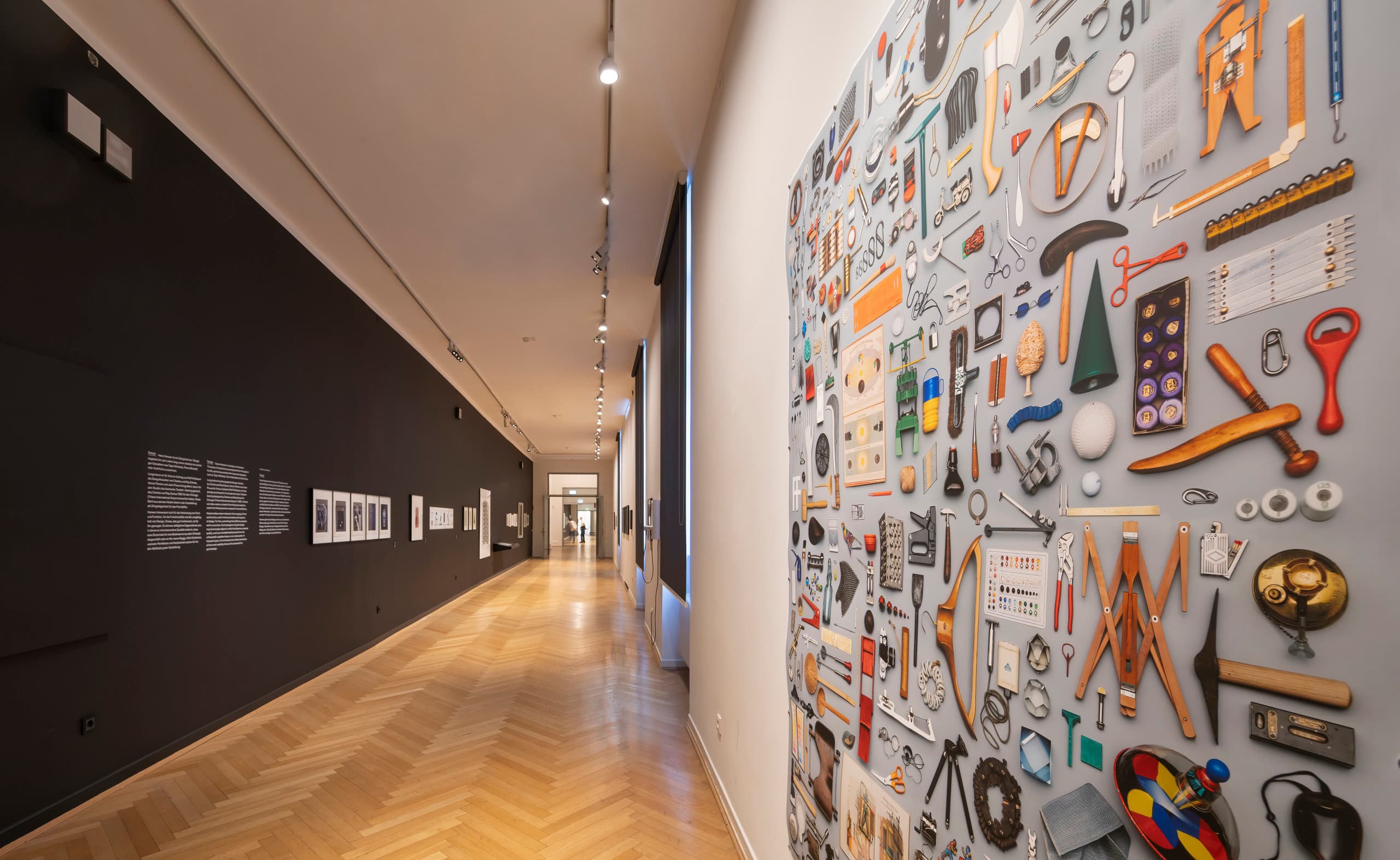 Gang, rechts großes Bild auf weißer Wand, links schwarze Wand.