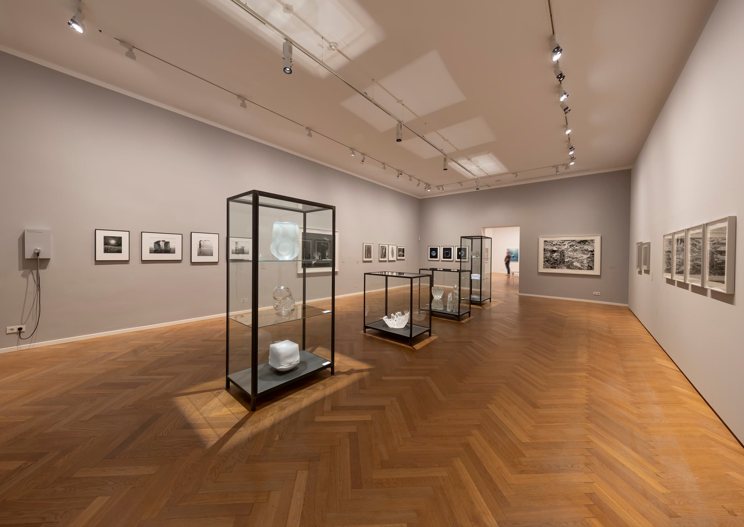 Ausstellungsraum mit mittig platzierten Vitrinen.