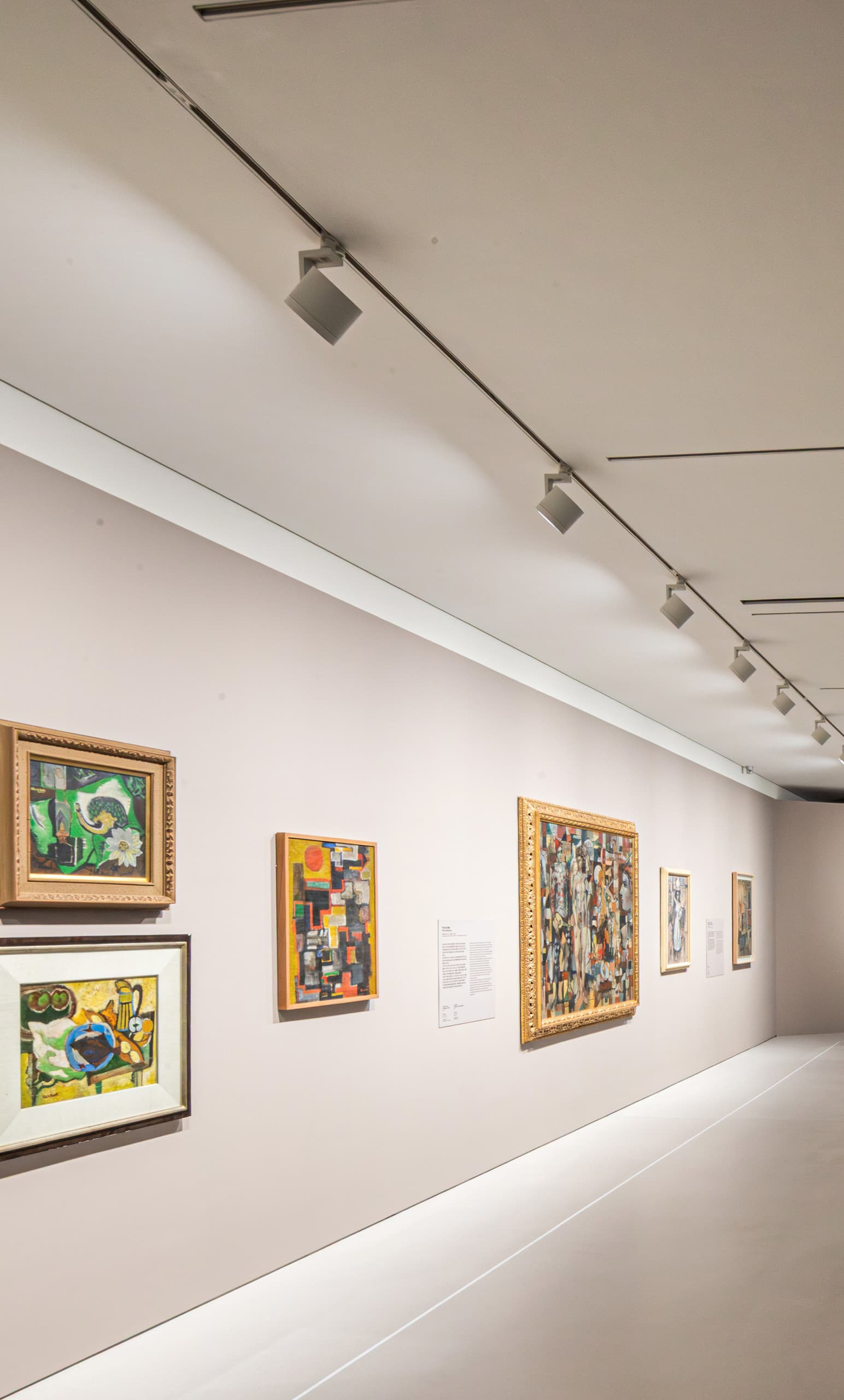 Ausstellungsraum mit beigen Wänden und Bildern.