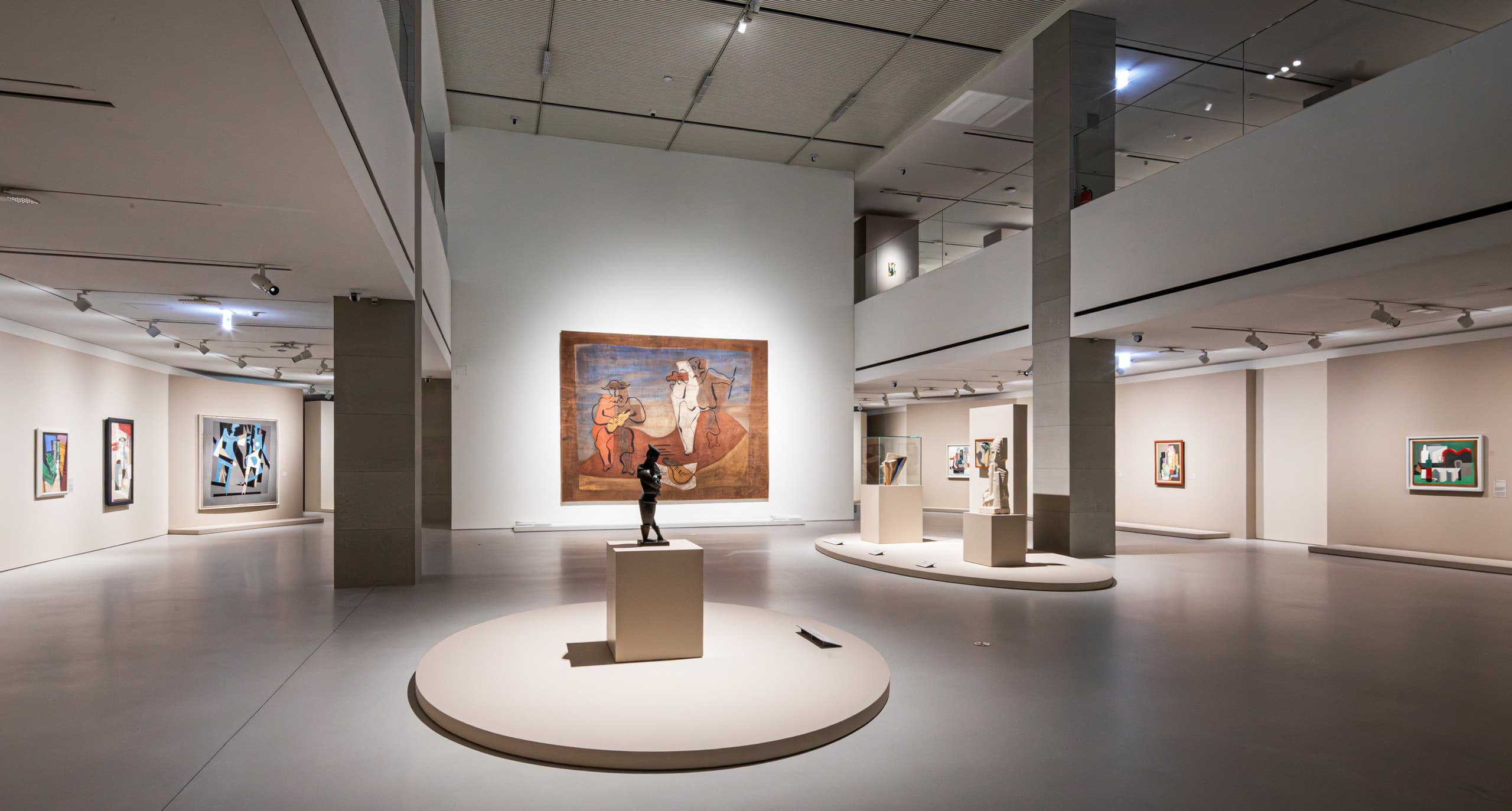 Großer Ausstellungsraum mit großem Bild und Skulptur im Fokus.
