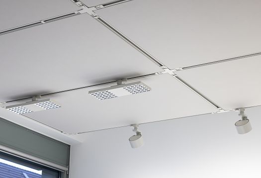 Detail of the office ceiling featuring a grid-patterned power track, integrated downlights and swivelling spotlights for precise, flexibly adjustable lighting.