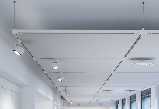 A ceiling view of a modern office featuring grid-patterned power rails and flexibly positioned spotlights for precise, adjustable general and task lighting.