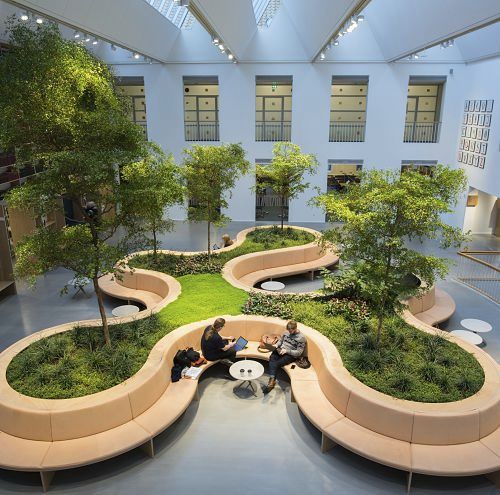 Gallery interior with green seating areas, illuminated by ERCO lighting solutions.
