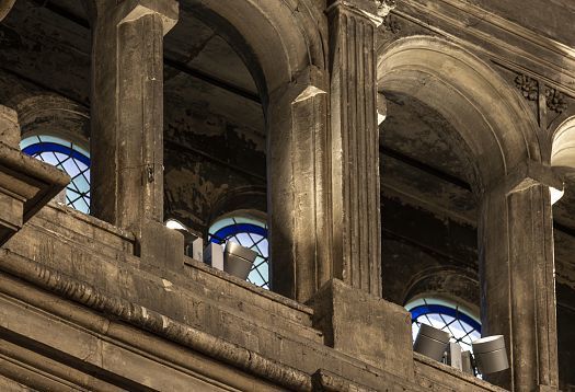 Veduta lungo la navata centrale dellinterno di una grande chiesa gotica con alte colonne in pietra, volte a crociera e vetrate istoriate. Banchi in legno distribuiti nello spazio e diversi visitatori camminano nella chiesa. Unimponente struttura lignea decorata si trova sulla sinistra, mentre laltare illuminato è visibile in lontananza.