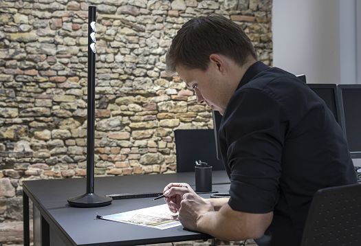 Person making notes at a desk – this visual task requires increased visual performance.