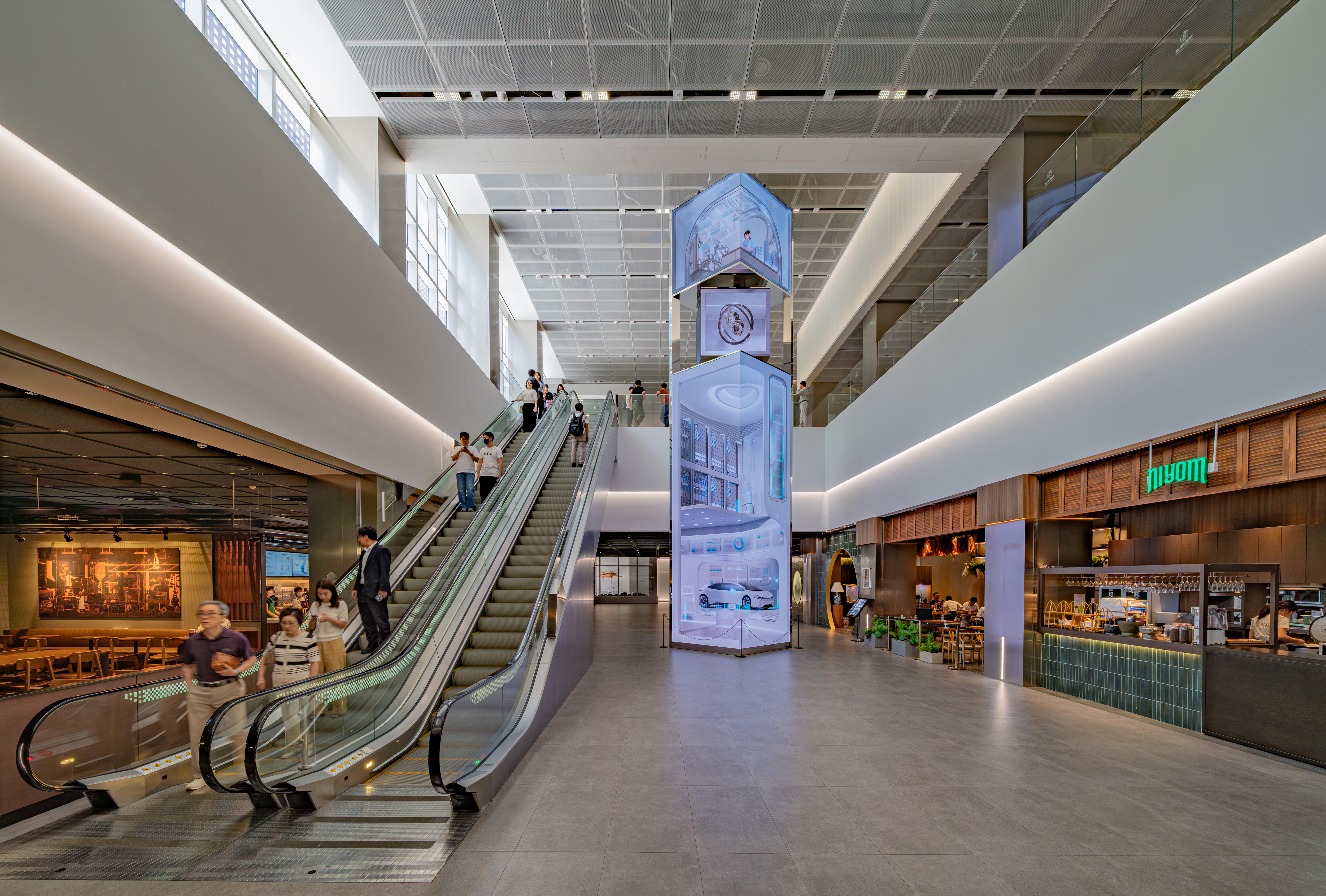 Modern multi-volume office lobby renovation at KT Gwanghwamun Building West in Seoul, featuring multi-height spaces lit by ERCO Jilly.